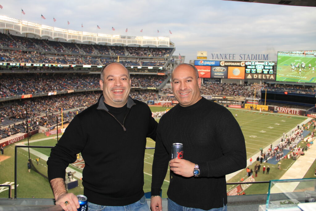 Mike Watkins standing in a stadium with his twin brother